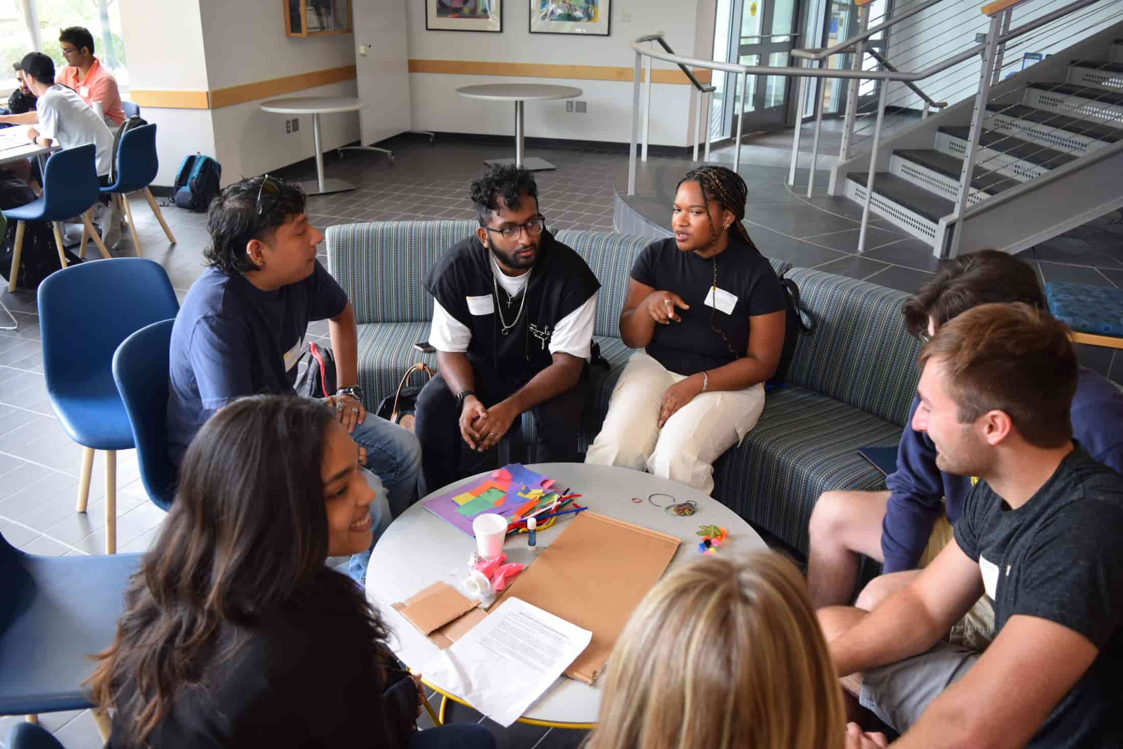 Grad students seated at a sofa in the LBME atrium