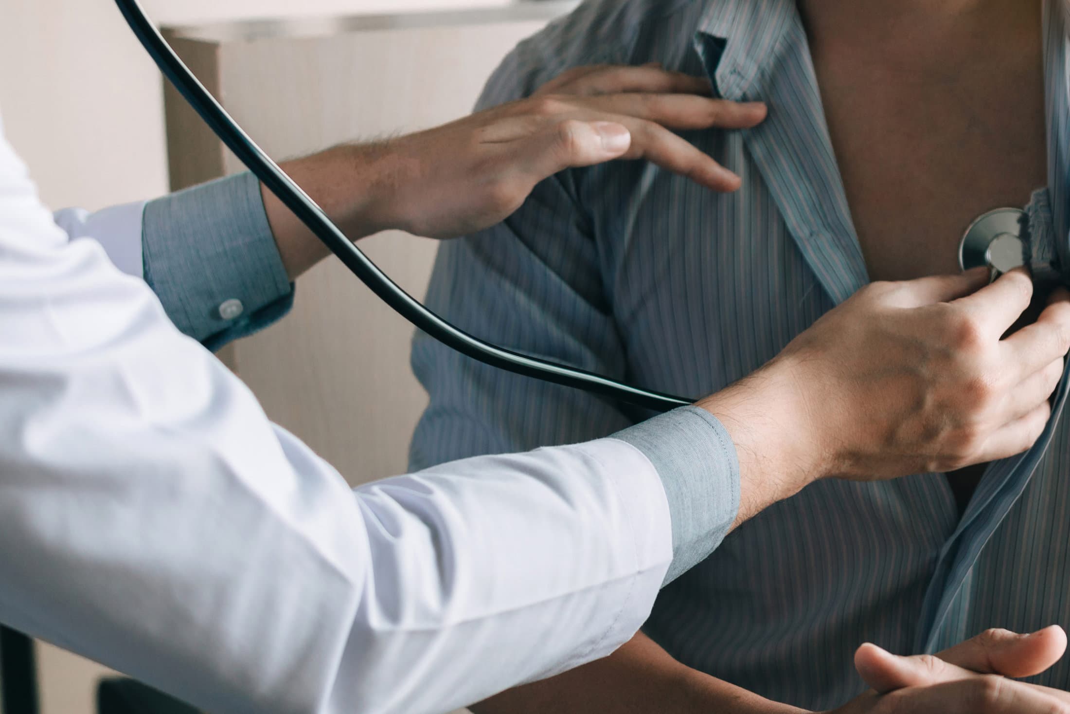 A medical person using a stethoscope on a patient