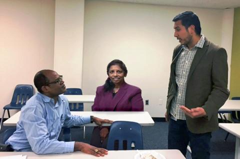 Three faculty talking in a classroom