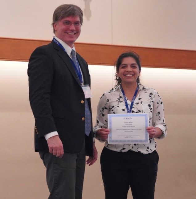 student holding a certificate she has just received